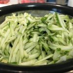 Grated zucchini squash draining in a wire strainer